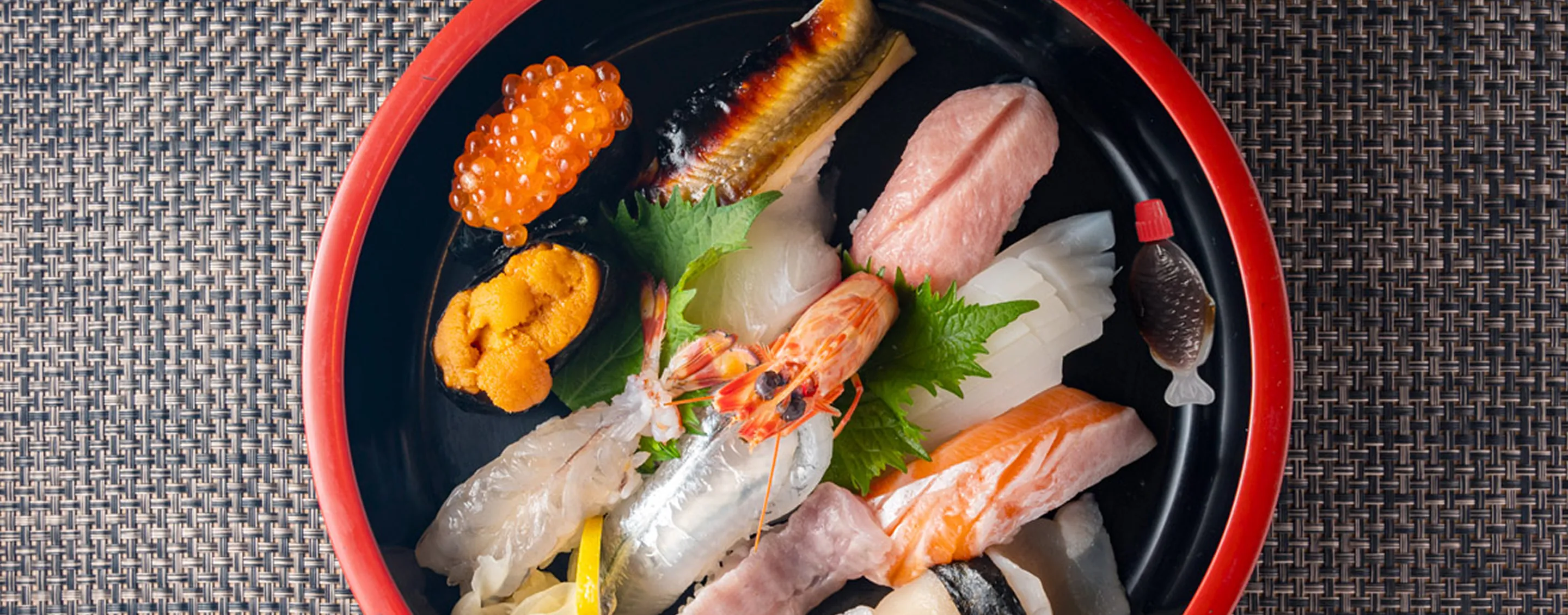 An assortment of colorful sushi arranged in a wooden tub